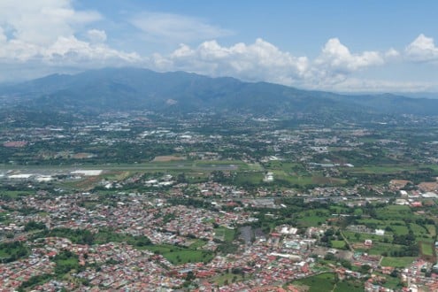 Vista aérea de una ciudad extendida en un amplio valle rodeado de montañas